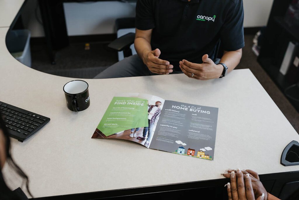 A Canopy agent showing a pamphlet to prospective customers.